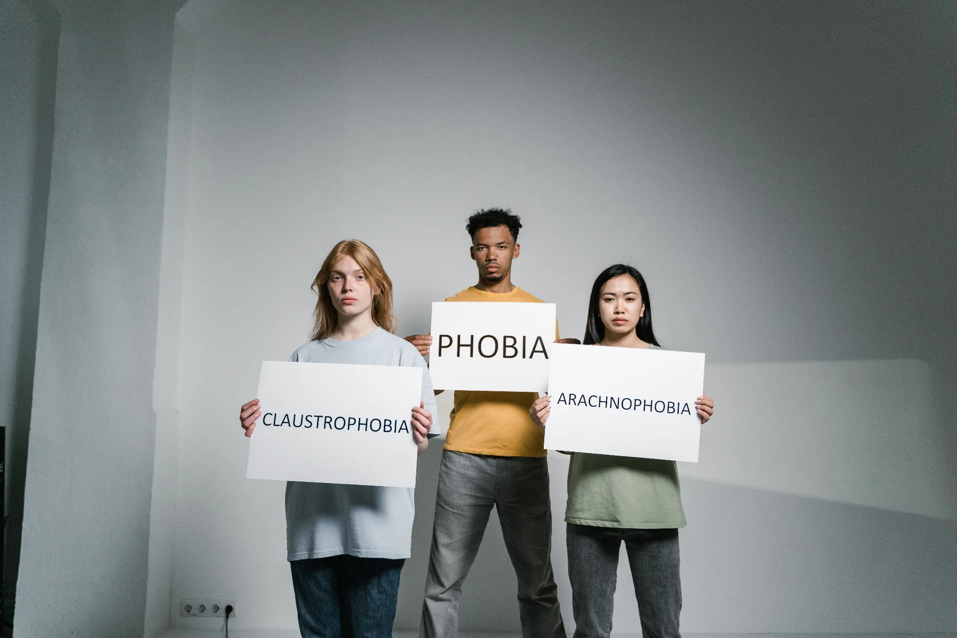 People holding signs naming common phobias