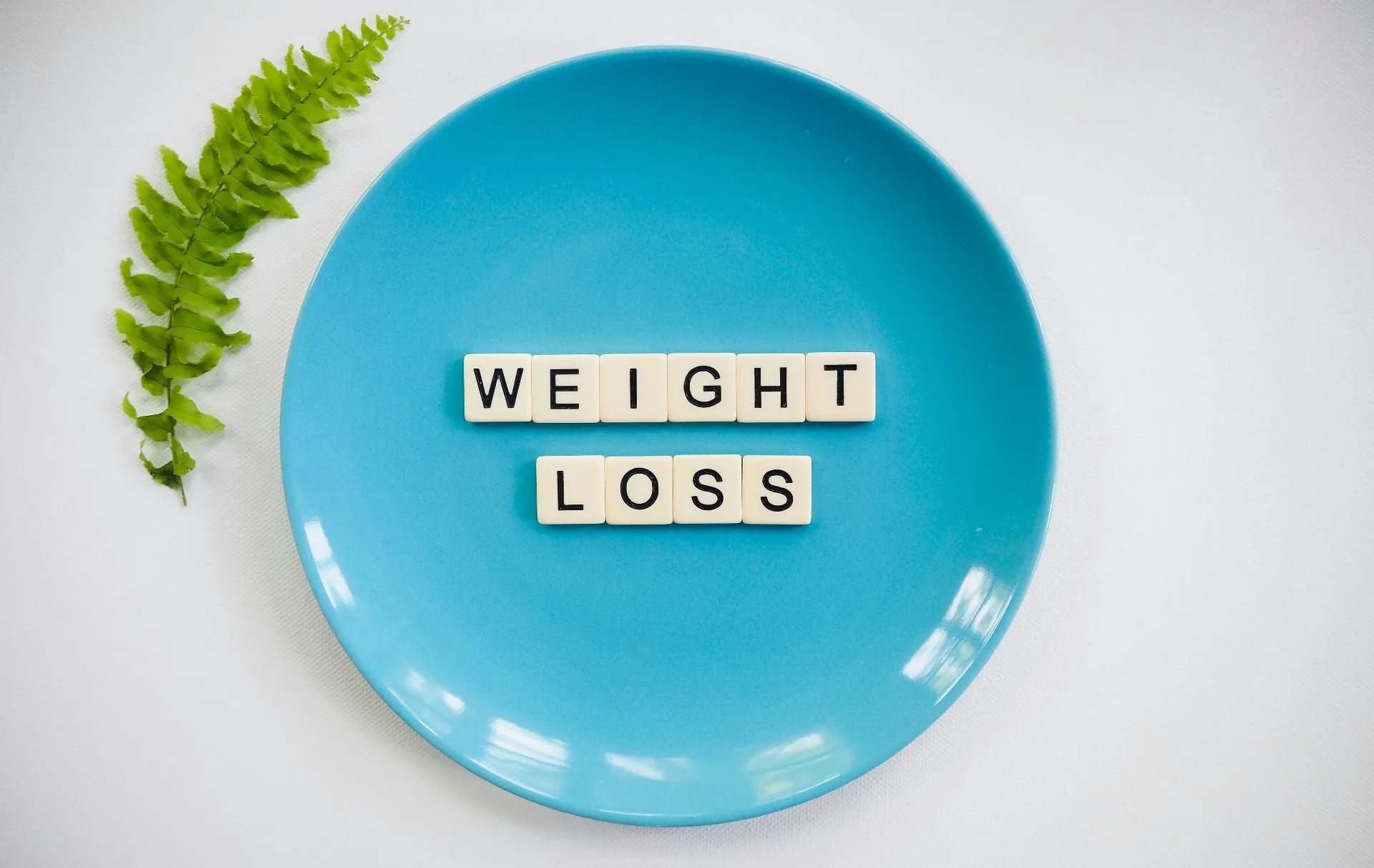 Letter tiles spelling weight loss on a plate